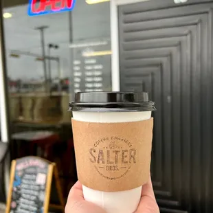 a hand holding a cup of coffee