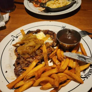 16 oz ribeye with sautéed onions, qith a side of fries and cognac pepper sauce.