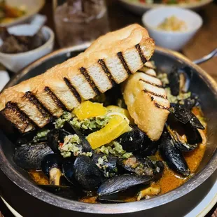 a plate of musselling with grilled bread