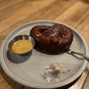 a pretzel and mustard on a plate