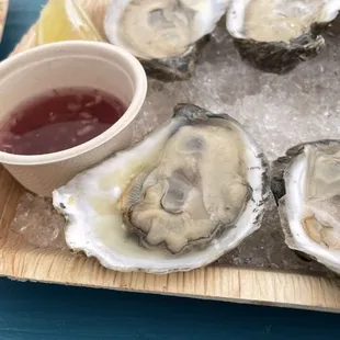 a plate of oysters with a side of dipping sauce