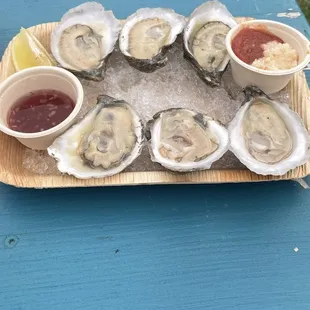 a platter of oysters with a side of ketchup