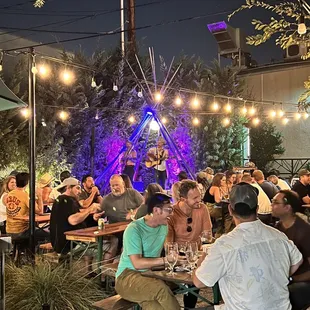 a group of people sitting at tables outside