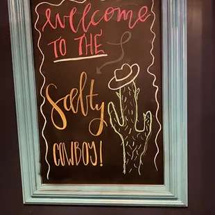 a chalkboard with a sign that says welcome to the salty cowboy