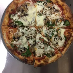 a pizza with mushrooms and spinach