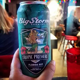 a person holding a can of beer