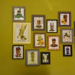 a variety of framed pictures on a green wall