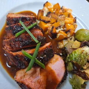 Ancho spiced pork tenderloin with a red wine reduction, butternut squash with aged cheddar and roasted brussels