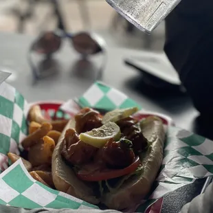 a person holding a sandwich and fries