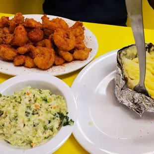 Shrimp dinner (bang bang and cajun shrimp) with slaw and baked potato.