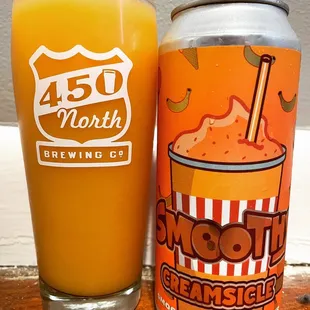 a glass of smoothie next to a can of smoothie