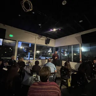 a group of people sitting at tables in a dimly lit room