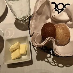 a table setting with bread, butter and water