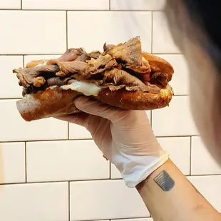 a person holding a sandwich in their hand