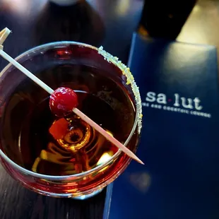 a cocktail with a cherry garnish