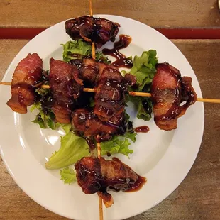 a plate of meat skewers with lettuce