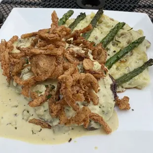 This is my beautiful steak accompanied by mashed potatoes and asparagus topped with crispy onions and a wonderful sauce.