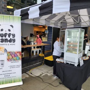 a woman standing in front of a food stand