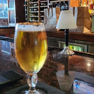 a glass of beer on a bar