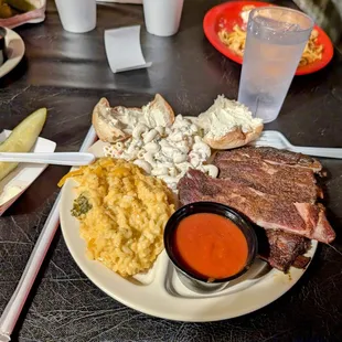 Pork ribs plate with broccoli n cheese and macaroni salad for sides. Spicy BBQ sauce on side.