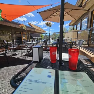 a view of a patio with tables and umbrellas