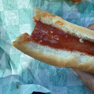 a hand holding a hot dog