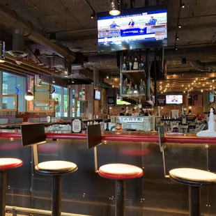 a bar with stools and a television