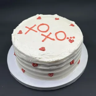 a white cake with red hearts