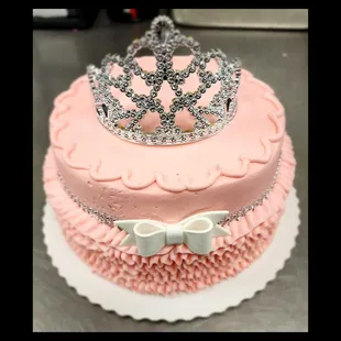 a pink cake with a tia on top