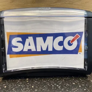 a samco logo on the side of a paper towel dispenser