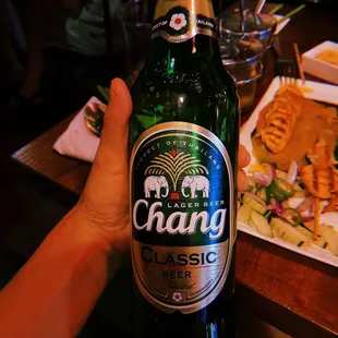 a person holding a bottle of beer