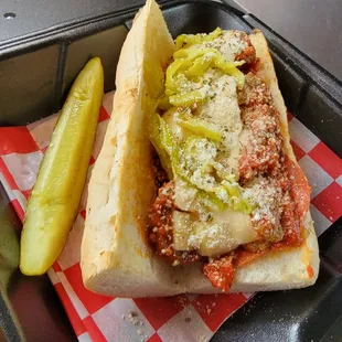a meatball sandwich and a pickle