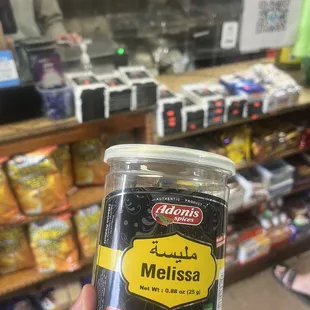 a hand holding a jar of mellissa