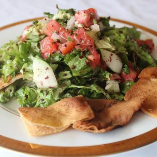a plate of salad with pita chips