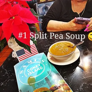 a woman sitting at a table with a bowl of soup
