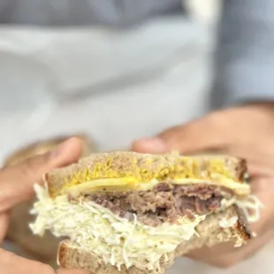 a person holding a sandwich in their hands