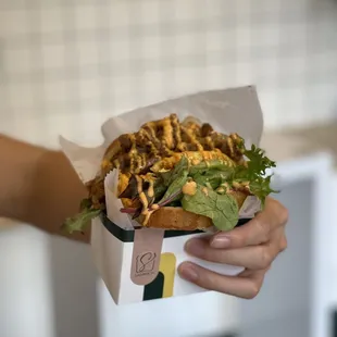 a hand holding a sandwich