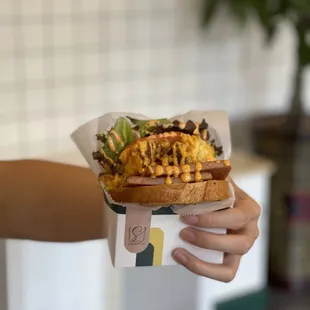 a hand holding a sandwich