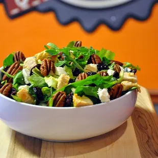 a bowl of salad on a cutting board