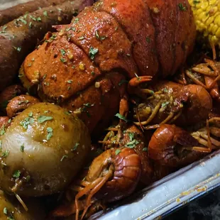 a platter of crawfish, potatoes, corn, and potatoes