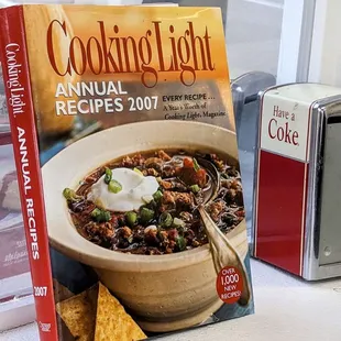 a cookbook and a book on a window sill