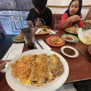 two people sitting at a table with plates of food