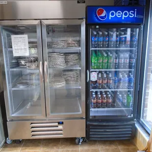 Coolers with frozen pizzas to-go and soda in 20 oz bottles.