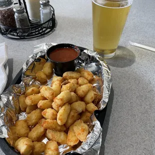 a plate of tater tots and a glass of beer