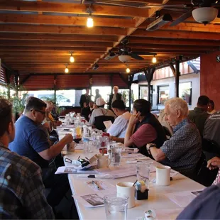 a large group of people sitting at a long table