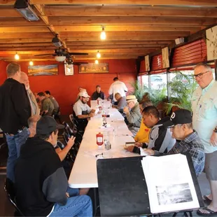 a group of people sitting at a long table