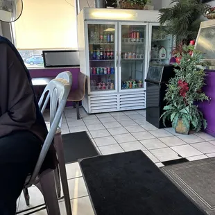 Small table and chairs along window to eat quickly or wait for food