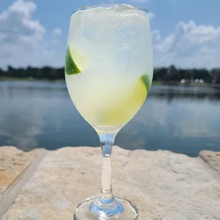 a glass of water with a lime slice in it