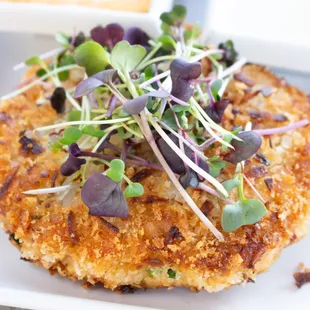 a crab cake with sprouts on top