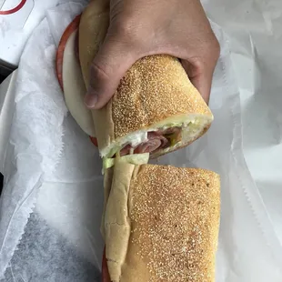 a hand holding a sandwich